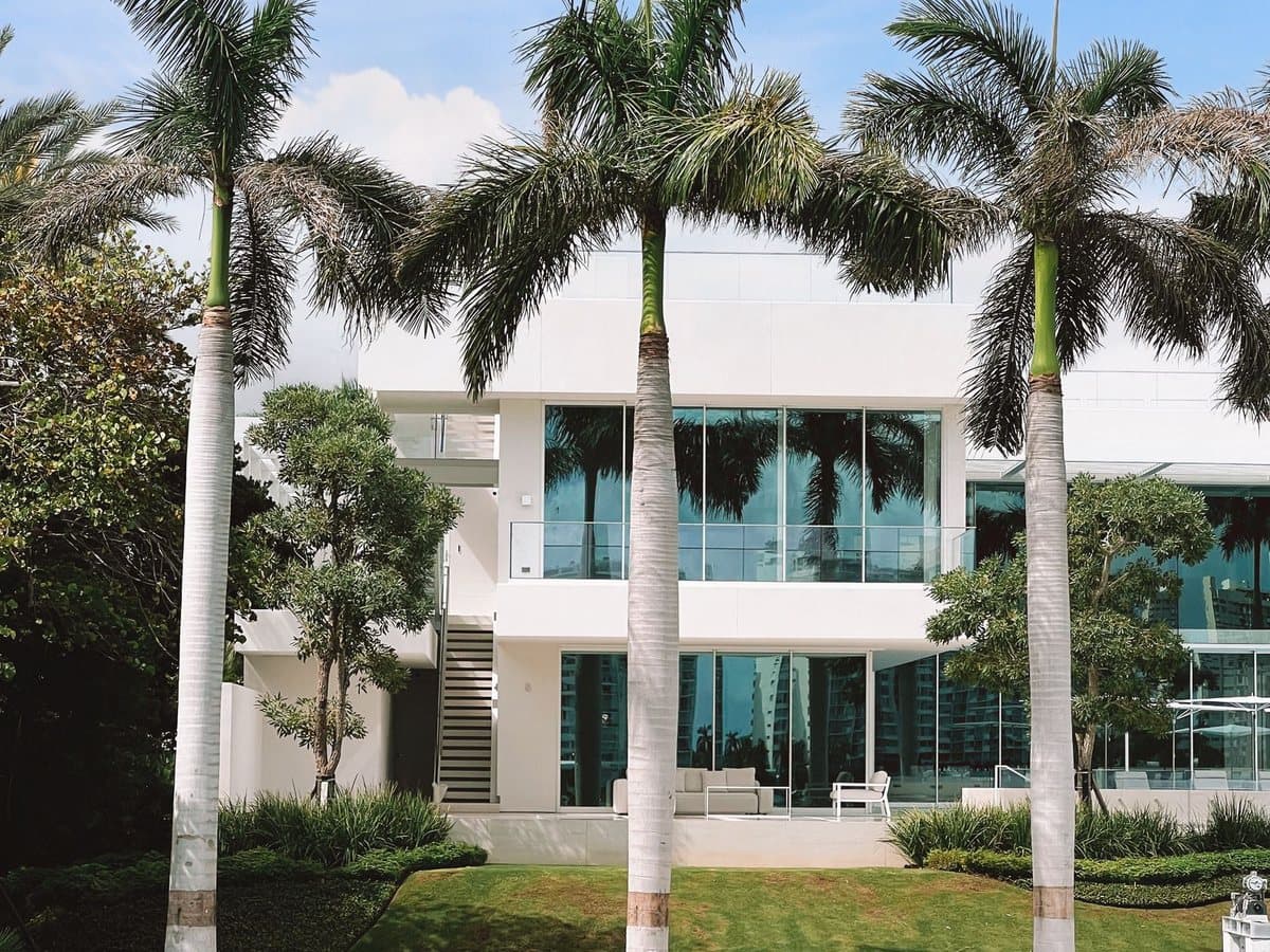 A just-listed Kailua home with a glass facade framed by palms. A social post Benjamin designed.
